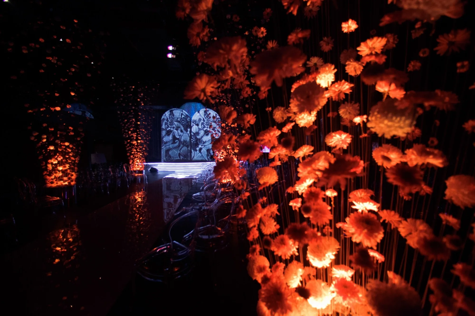 An evening venue in Tokyo with layered ambient and laser lighting creating a quiet atmospheric glow